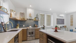 Una cocina moderna con armarios de madera, una isla central y un horno empotrado.
