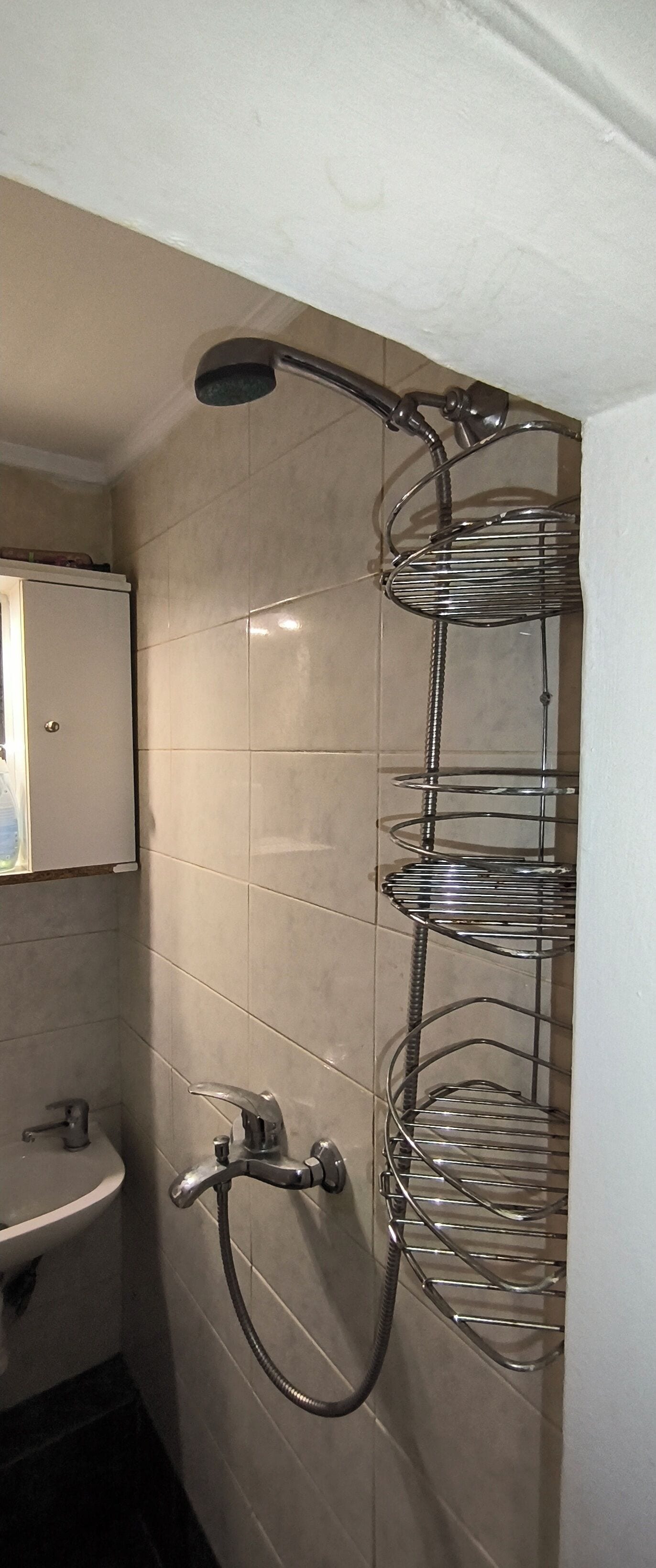 A bathroom with a shower, a sink, and a mirror.