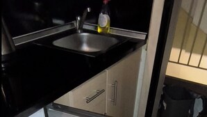 A kitchen with a refrigerator, sink, and a bag on the floor. - Thessalonik Apartment-heart of City (Thessaloniki)