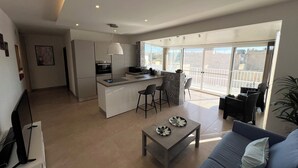 Un appartement moderne doté d’une cuisine, d’un coin repas et d’un balcon avec vue.