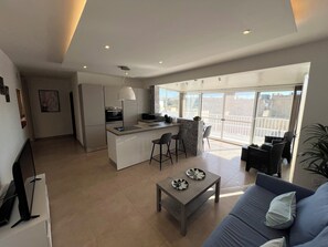 A modern apartment with a kitchen, dining area, and a balcony with a view. - Luxury Penthouse 2-bedroom Jacuzzi  in Ix-Xagħra (Ix-Xagħra)