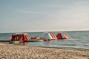 Una playa con estructuras inflables y cielo despejado.