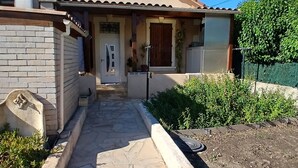 Una casa con un sendero de piedra que lleva a la entrada, un muro de ladrillo y un jardín.