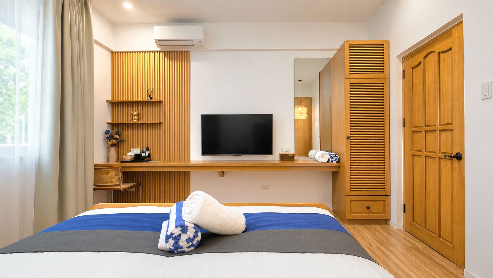 Ein Hotelzimmer mit Bett, Fernseher, Holzmöbeln und einem Kleiderschrank.