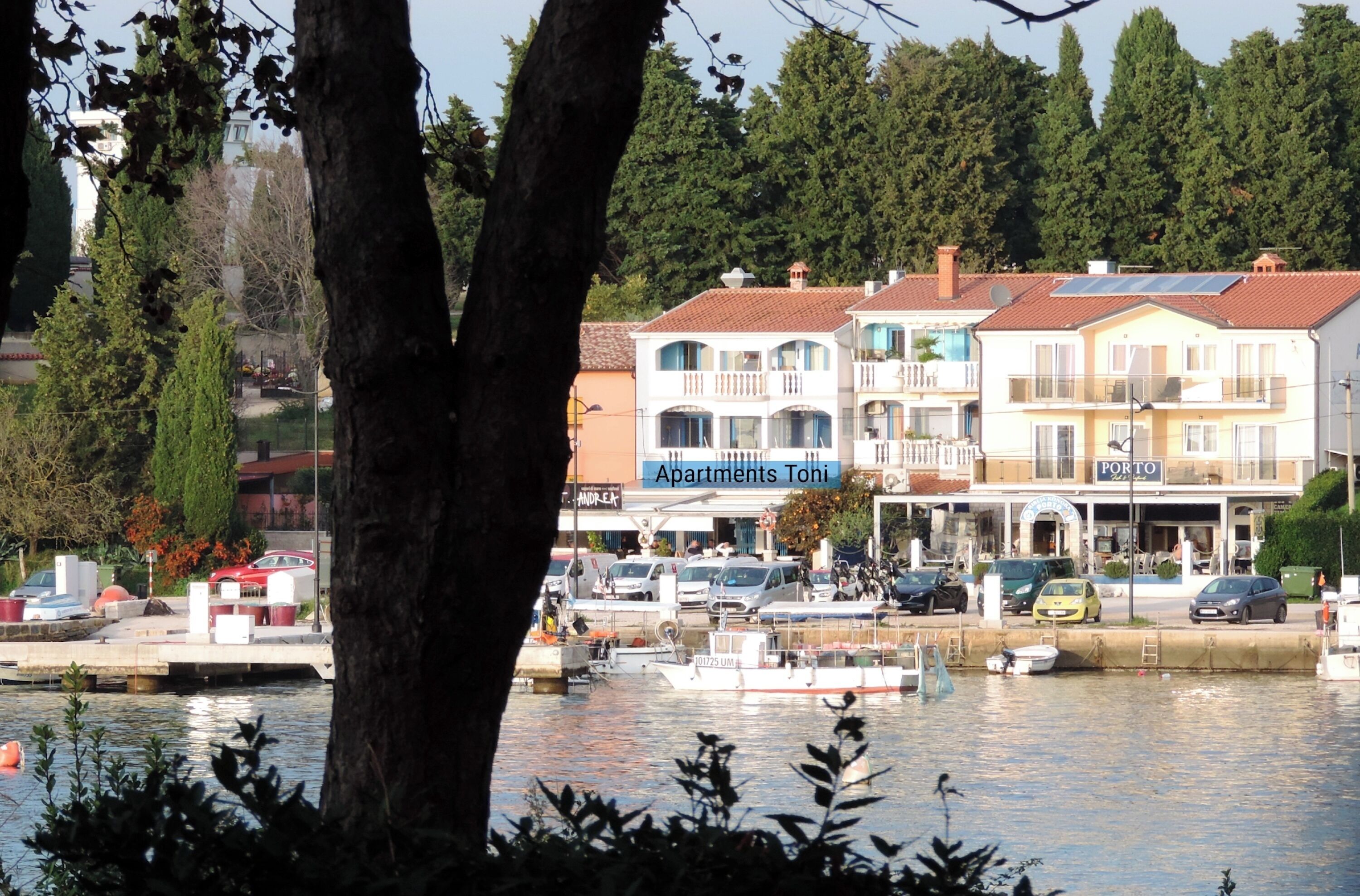Une propriété située au bord de l’eau, dotée de plusieurs balcons, d’un restaurant appelé « Porto » et d’une marina avec des bateaux.