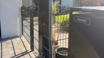 Un espacio al aire libre con una reja de metal, una planta en maceta y un letrero que indica un apartamento.