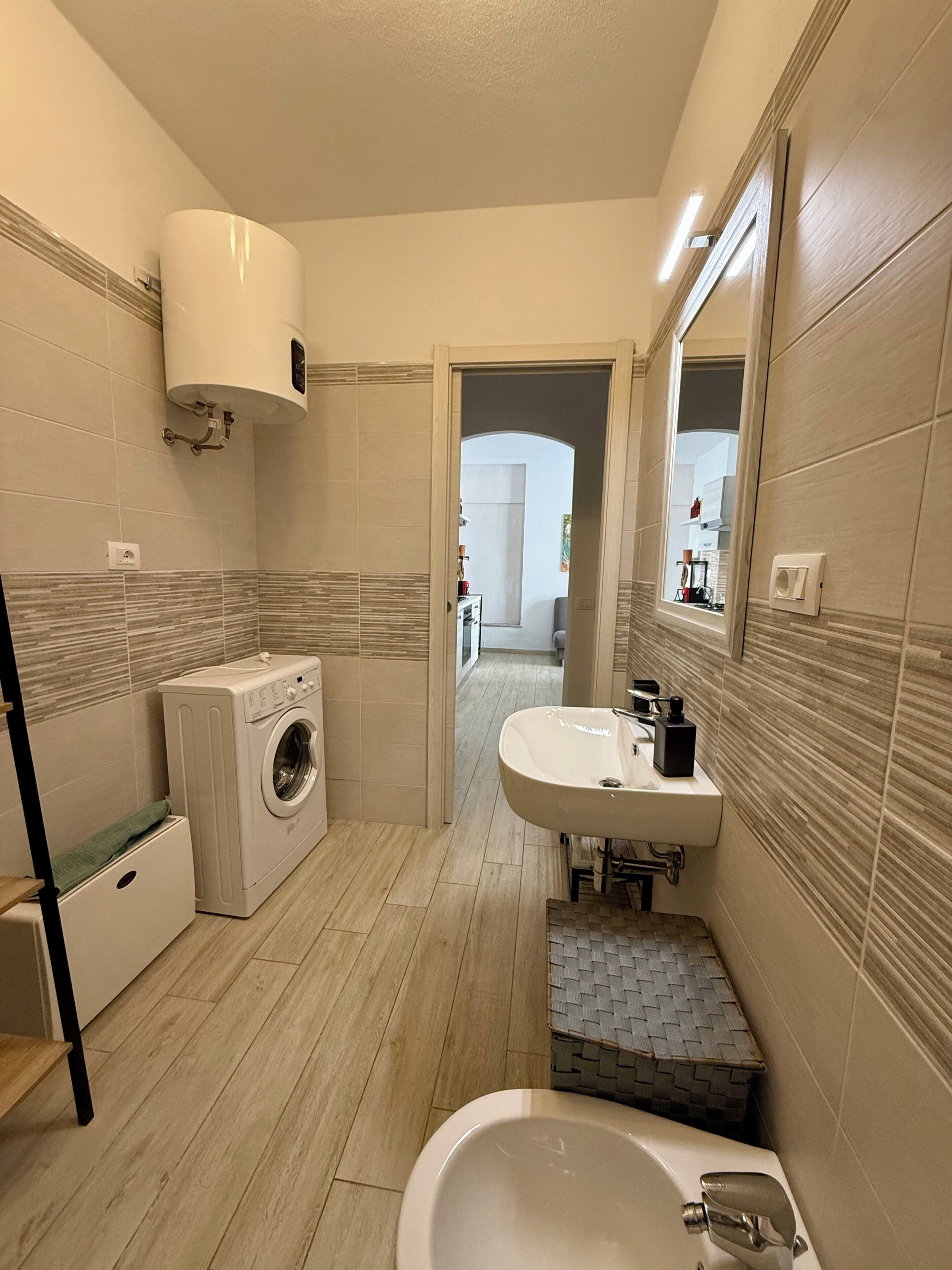 Un baño pequeño con lavadora, lavamanos y bañera.