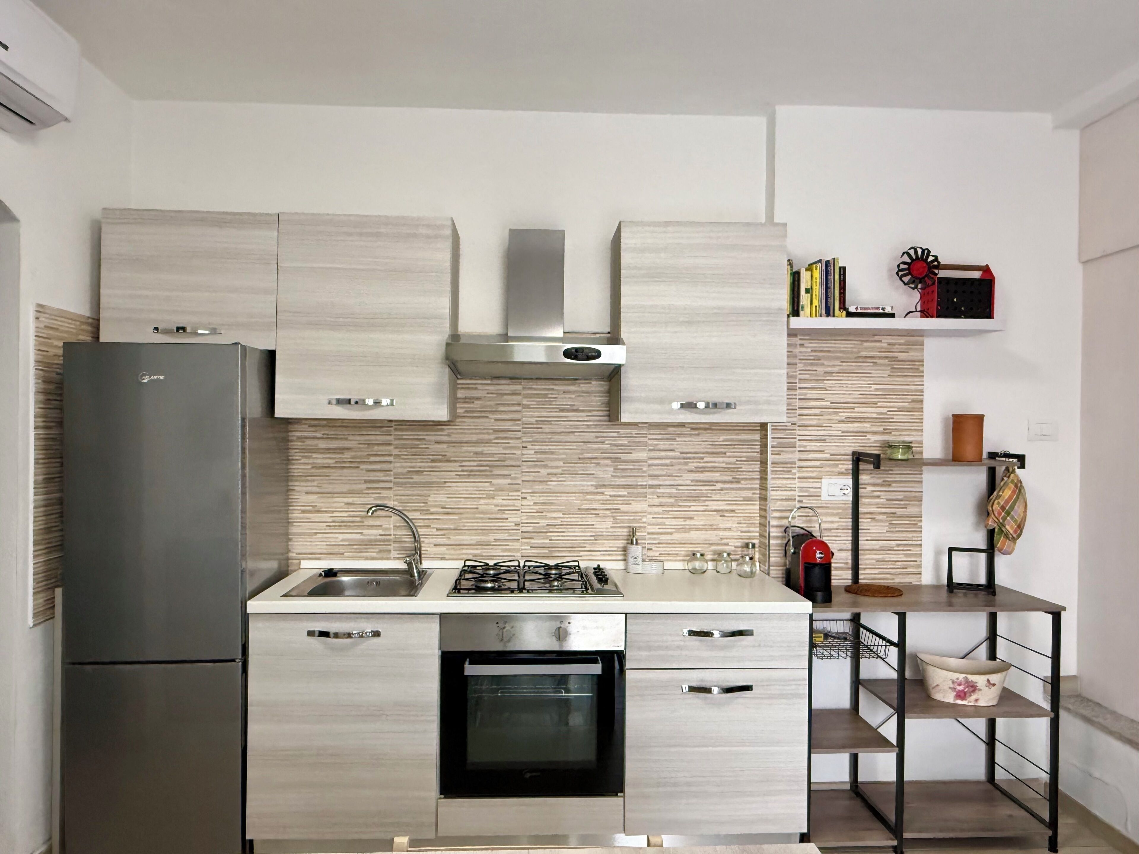 Een moderne keuken met roestvrijstalen apparatuur, houten kastjes en een inbouwoven.