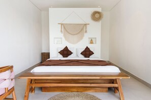 A bed with a wooden frame, a white mattress, and brown pillows. - La Joie Villa by Tasvan (Badung)