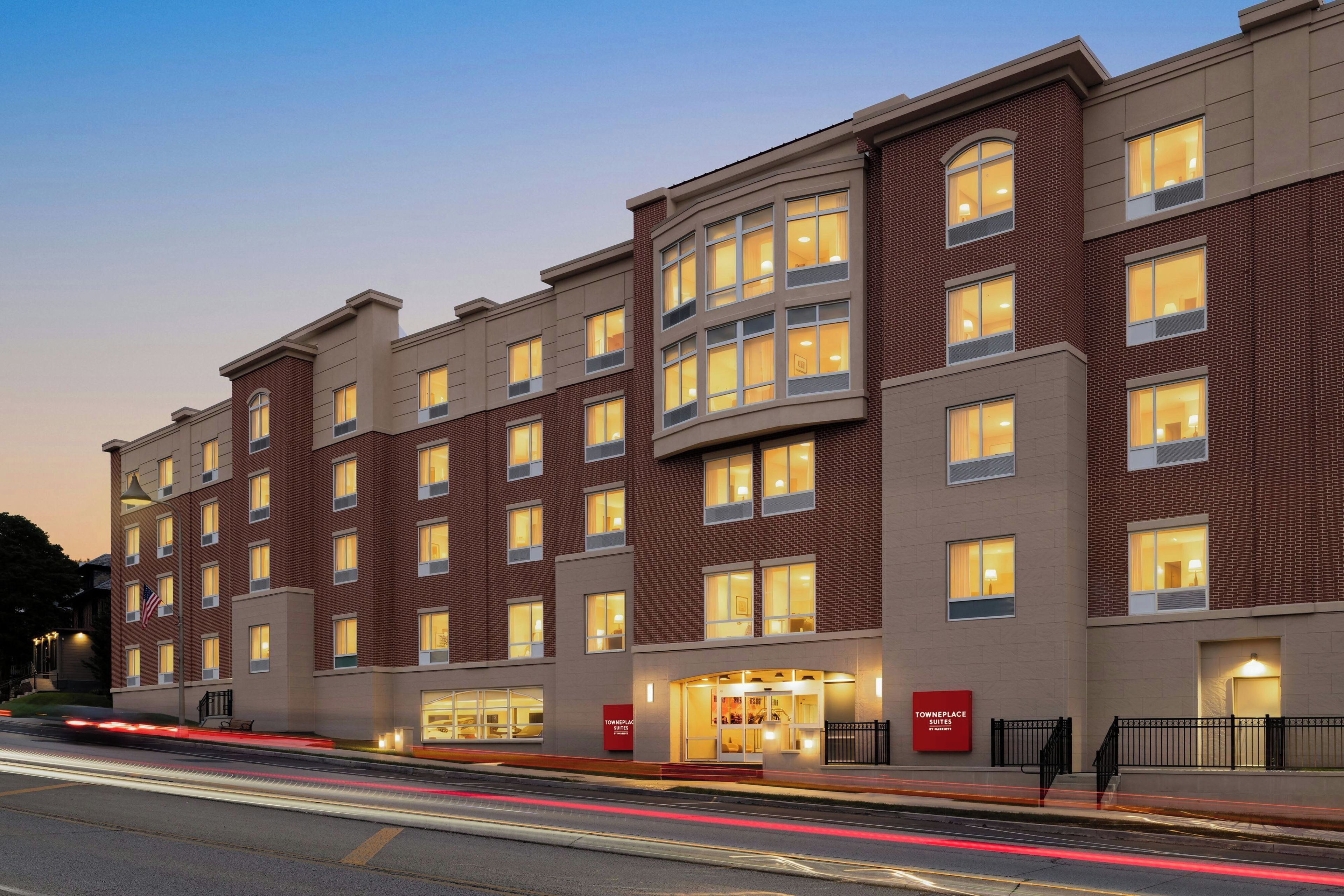 A multi-story hotel with a brick facade, multiple windows, and a well-lit entrance.