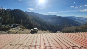 Un paisaje montañoso con cielo despejado y sol radiante.