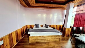 Una habitación con una cama de madera, una mesa y sillas.