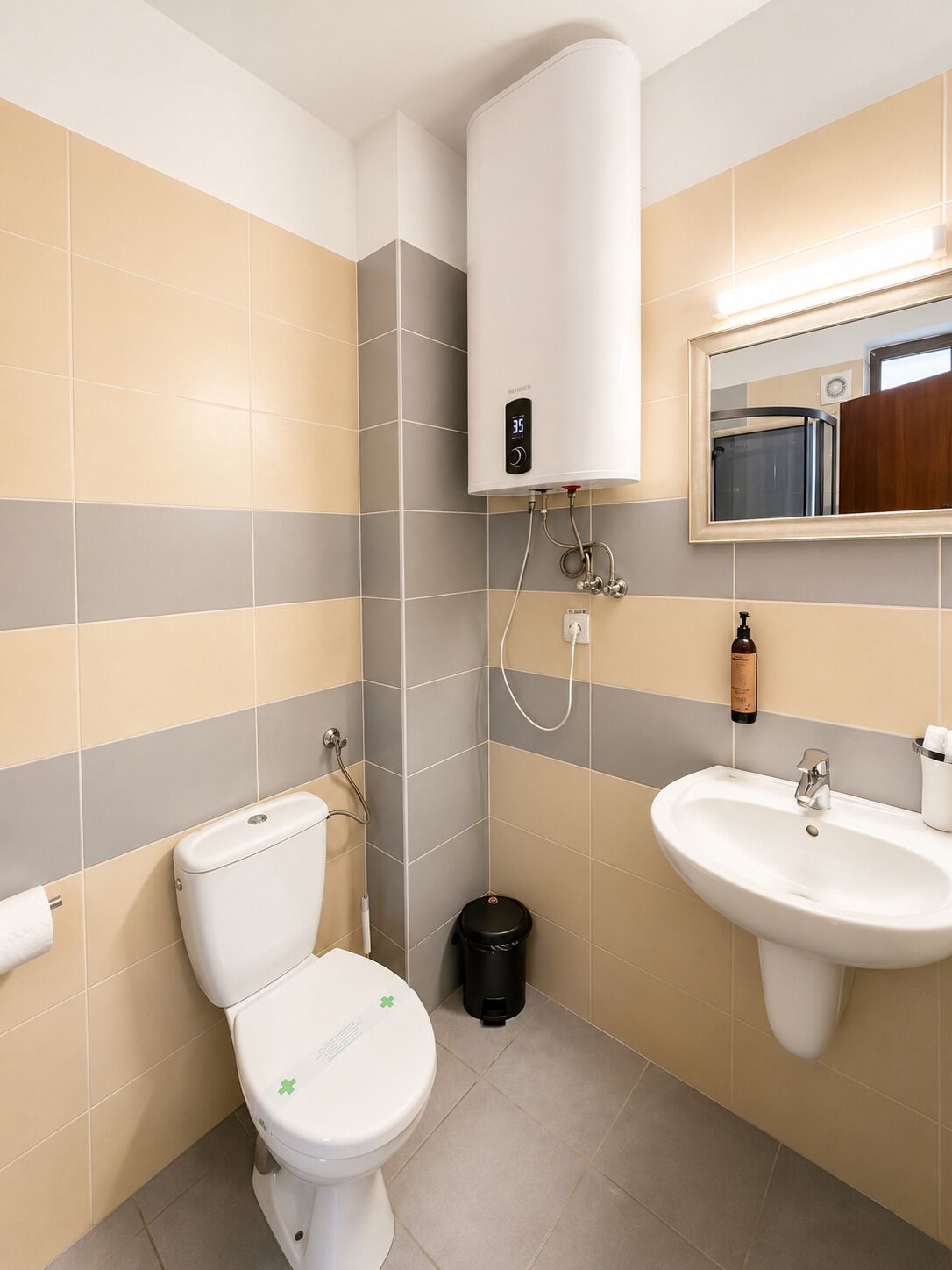 A bathroom with a toilet, sink, and a water heater.