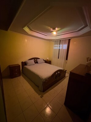 A bedroom with a bed, nightstands, a dresser, and a ceiling light fixture. - Bright 100m2 King balcony apartment (Mohammédia)