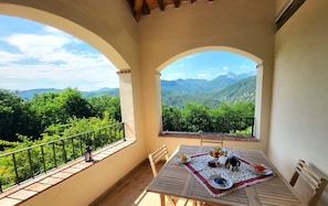A balcony with a table set for two, overlooking a mountainous landscape. -  NEW! Perfect for 2! Private Pool, mountain Views, covered terrace. Romance! (Toscana)