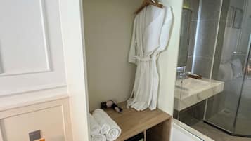 Regadera, secadora de cabello, pantuflas, toallas