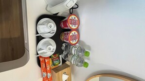 Un baño con lavamanos, espejo y espacio para artículos de aseo.