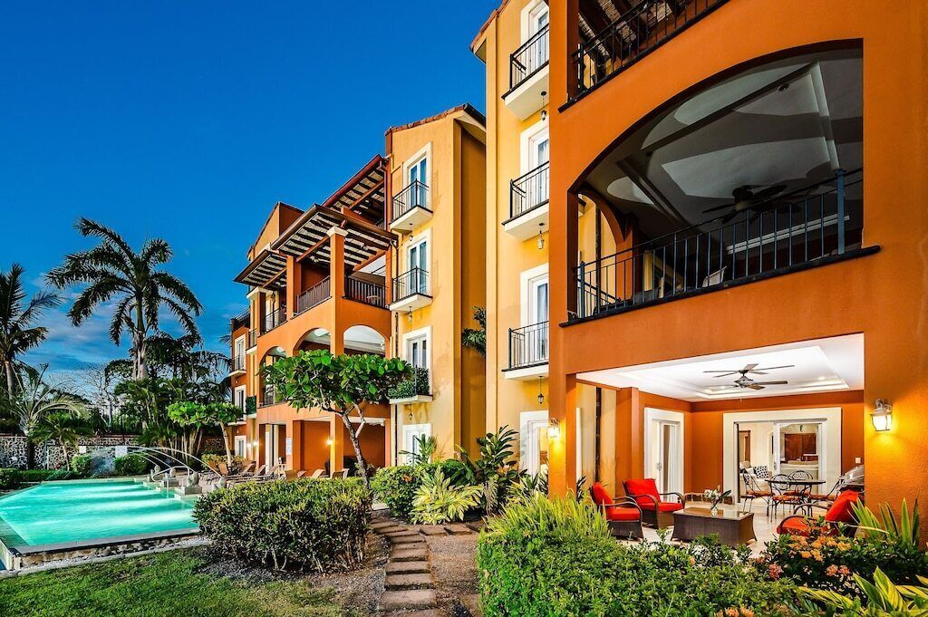 Ein Hotel mit Pool, Außenbereich und einem gepflegten Garten.