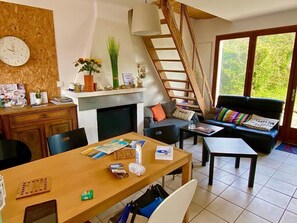 Ein Wohnzimmer mit Kamin, Essbereich, einer Couch und einer Treppe.
