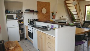 Eine kleine Küche mit Mikrowelle, Herd, Spüle und Holzschränken.
