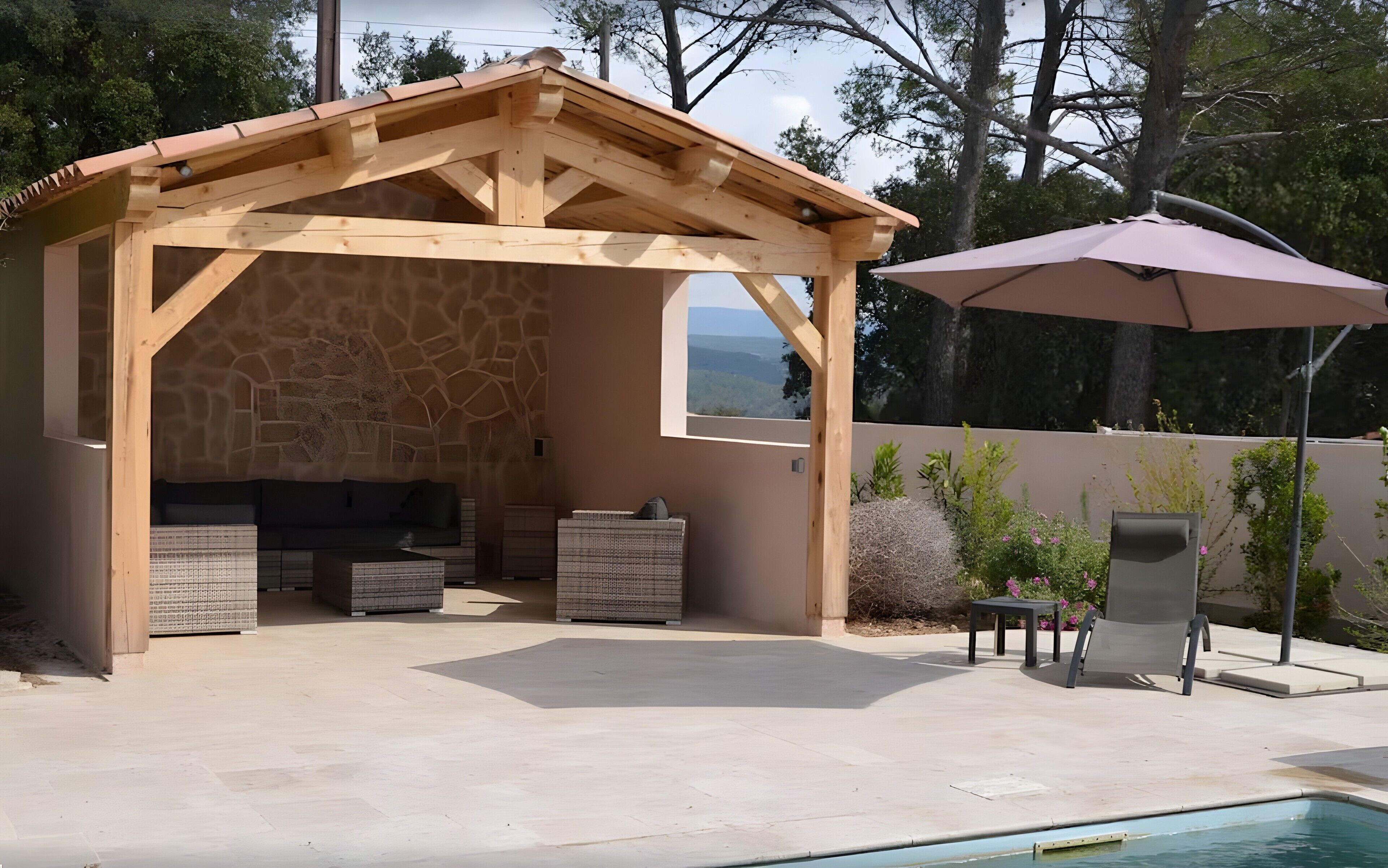 A covered outdoor area with a stone wall, a pool, and a patio with a table and chairs.