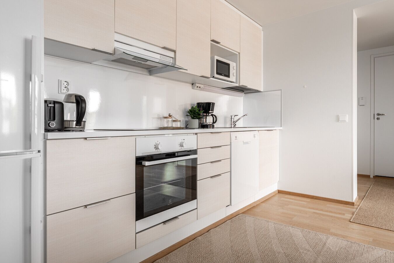A modern kitchen with a built-in oven, microwave, and coffee maker.