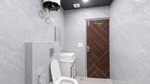 A modern bathroom with a toilet, sink, and shower. - Mauryan Signature Hotel NHPC Metro (Faridabad)