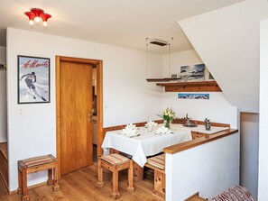 Ein Essbereich mit einem Holztisch, Bänken und einer weißen Tischdecke.