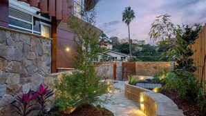A landscaped outdoor area with stone walls, a pathway, and various plants. - The Solstice, Neutral Bay Isyd (Neutral Bay)