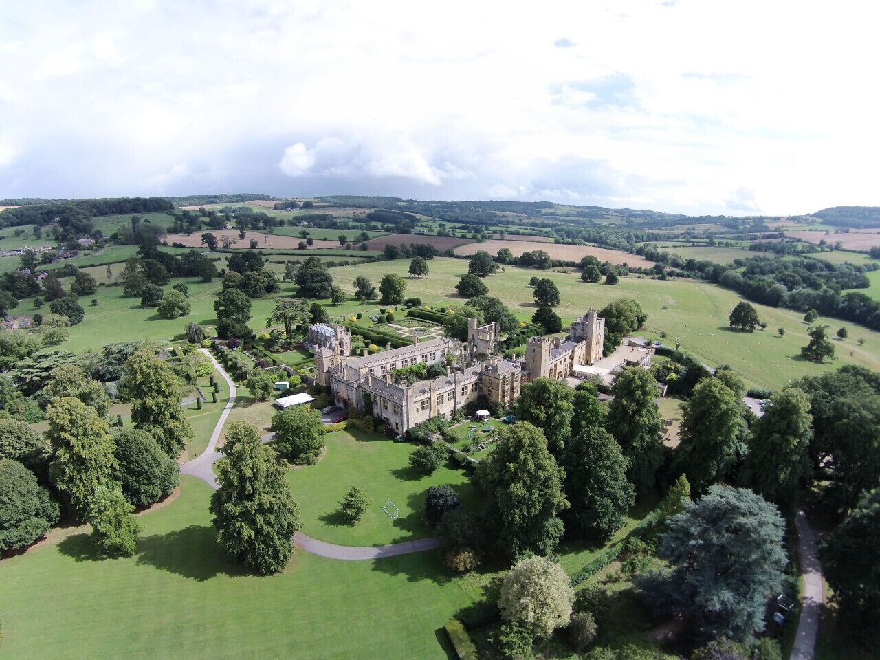 A large castle surrounded by lush green fields and trees.