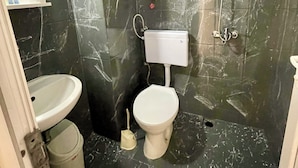 A bathroom with a toilet, sink, and shower.