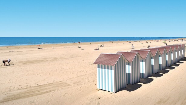 A beach with rows of striped beach huts and a sandy beach. - La Grainette by Interhome (Saint Jean de Monts)