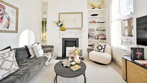 Un salon moderne avec une cheminée, un canapé, une table basse et une bibliothèque.