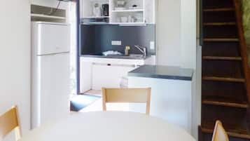 Eine kompakte Küche mit Essbereich, einem integrierten Fernseher und einer Treppe.