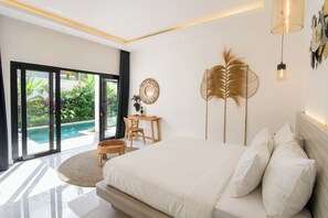 Ein Schlafzimmer mit einem großen Bett, einem Schreibtisch und Blick auf einen Swimmingpool.