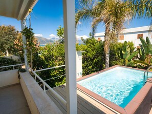 A pool with a clear view of the sea and mountains in the background.