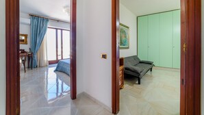 Um quarto com uma cama, uma escrivaninha e um guarda-roupa verde.