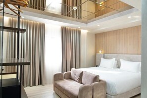 Ein modernes Hotelzimmer mit einem großen Bett, einer Sitzecke, einem Schreibtisch und Blick auf die Stadt durch große Fenster.