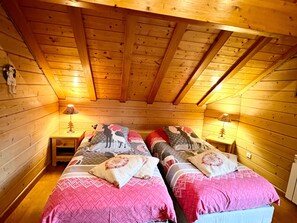 A cabin-style bedroom with two beds, wooden walls, and a sloped ceiling. - Spacious chalet, pets allowed - ? guests (Gérardmer)