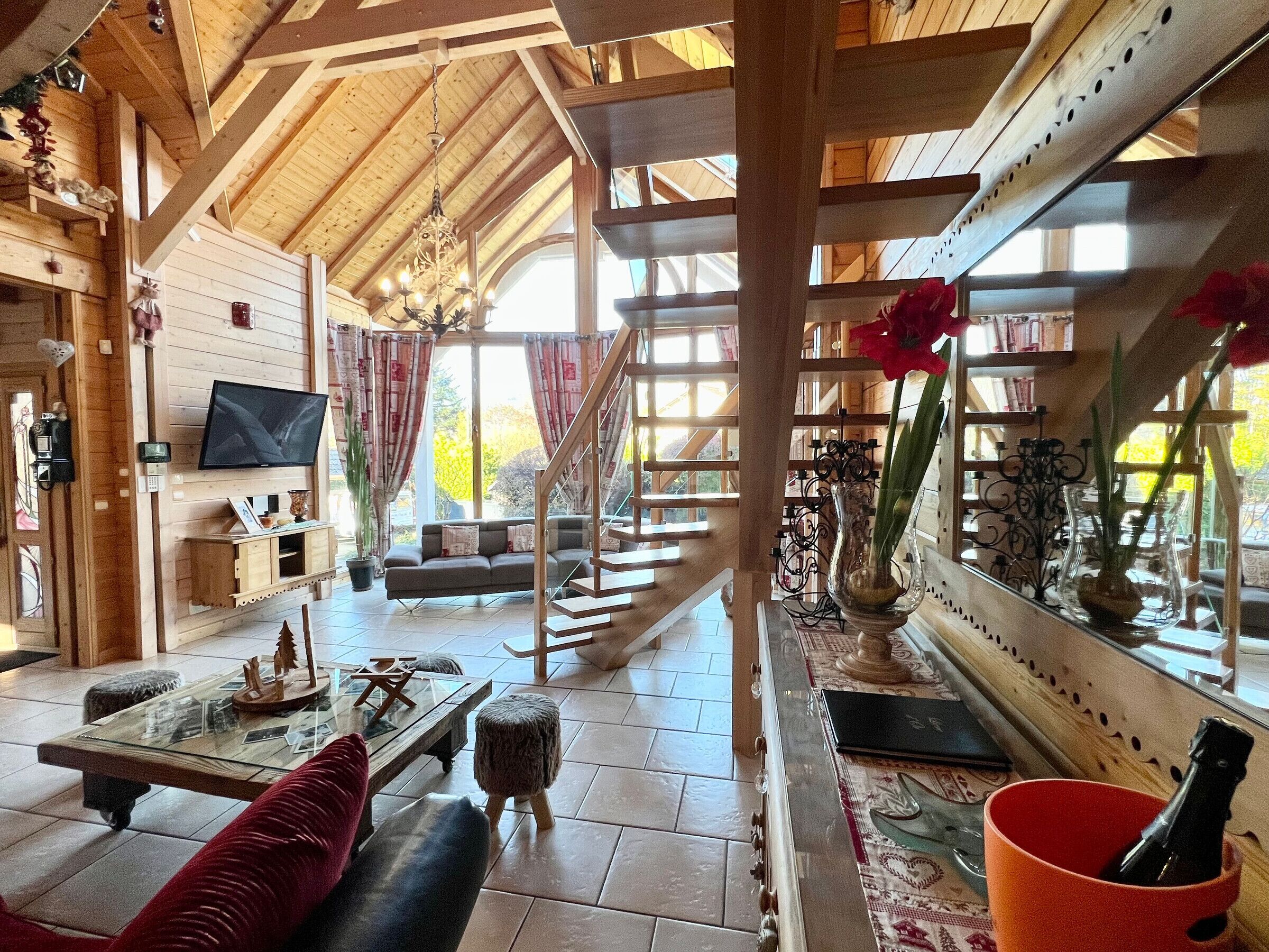 Ein Holzinnenraum mit Fernseher, Sofa und einer Treppe.