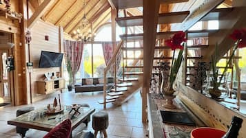 Ein Holzinnenraum mit Fernseher, Sofa und einer Treppe.