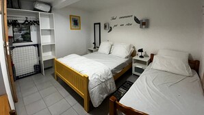 Un dormitorio con dos camas, un armario, un espejo y un adorno en la pared.