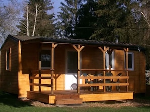 Eine Holzhütte mit Veranda, Tür und Fenstern.