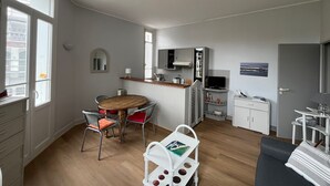 Un espace de vie compact comprenant un coin repas, une kitchenette et un petit coin salon.
