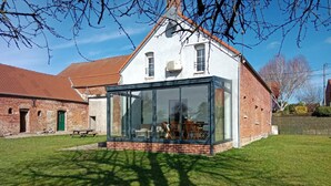 A modern house with a glass extension, a brick exterior, and a well-maintained lawn. - Independent house, pets welcome - 6 guests (VENDEGIES SUR ECAILLON)