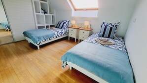 A bedroom with two beds, a skylight, a white wardrobe, and a wooden floor. - Independent house, pets welcome - 6 guests (VENDEGIES SUR ECAILLON)