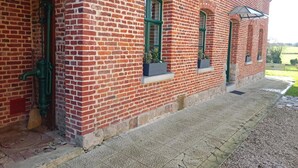 A red brick building with green windows and a small porch area. - Independent house, pets welcome - 6 guests (VENDEGIES SUR ECAILLON)