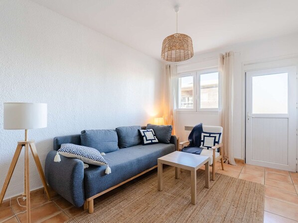 Ein modernes Wohnzimmer mit einer Couch, einem Couchtisch, einer Lampe und einer Lampenschirm aus Weidengeflecht.