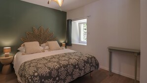 A bedroom with a bed, bedside lamps, a window, and a wall-mounted shelf. - Single-storey house, pets welcome - 4 guests (Silly-en-Gouffern)