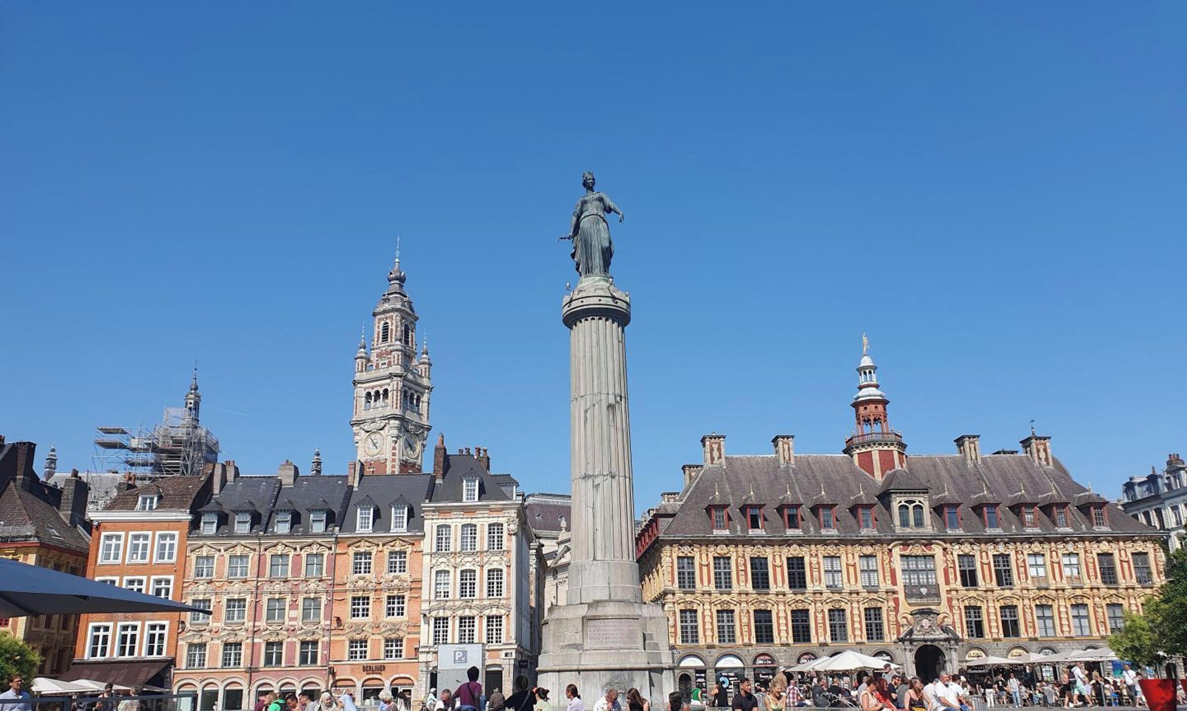 A historic square with a central monument, surrounding buildings with classic architecture, and a clock tower.